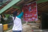 Relawan Palang Merah Indonesia (PMI) sedang memasang poster untuk melakukan diseminasi informasi terkait COVID-19 kepada warga. (Antara/HO/PMI/IFRC).