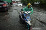 Pengendara mendorong sepeda motor saat melintasi genangan air yang merendam kawasan Gedebage, Bandung, Jawa Barat, Kamis (17/6/2021). Genangan setinggi 40 cm hingga 60 cm merendam kawasan tersebut akibat tingginya curah hujan serta drainase yang kurang baik yang kerap mengganggu arus lalu lintas. ANTARA FOTO/Novrian Arbi/agr