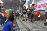 Dua orang pemuda memberikan hiburan saat kegiatan edukasi tentang pentingnya Perilaku Hidup Bersih dan Sehat (PHBS) di masyarakat oleh relawan PMI di Kelurahan Benteng, Kecamatan Warudoyong, Jawa Barat. (Antara/HO/PMI/IFRC).