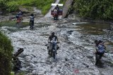 Pengendera sepeda motor menyeberangi di Sungai Sintok yang dangkal di Desa Ciparakan, Kecamatan Kalipucang, Kabupaten Pangandaran, Jawa Barat, Jumat (18/6/2021). Akibat tidak ada jembatan selama puluhan tahun, warga di Kecamatan Kalipucang, Sidamulih dan Padaherang, terpaksa harus menyeberangi sungai untuk melakukan aktivitas dan jika debit air sungai naik atau meluap aktivitas warga terganggu karena tidak bisa dilalui. ANTARA FOTO/Adeng Bustomi/agr