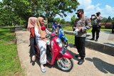 Petugas kepolisian memberikan pemahaman penerapan protokol kesehatan kepada pengunjung yang tidak mengenakan masker saat berwisata di Candi Gumpung, Kawasan Percandian Muarajambi, Muarojambi, Jambi, Minggu (20/6/2021). Petugas kepolisian resor setempat kembali menggencarkan sosialisasi penerapan protokol kesehatan, utamanya di sejumlah tempat wisata dan keramaian menyusul ditetapkannya kabupaten itu sebagai daerah zona merah atau risiko tinggi penularan COVID-19. ANTARA FOTO/Wahdi Septiawan/hp.