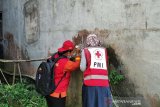 Relawan Palang Merah Indonesia (PMI) dan Satgas Jumantik sedang mengamati kemungkinan adanya jentik nyamuk di sekitar rumah warga di Desa Sokaraja, Kecamatan Pagentan, Kabupaten Banjarnegara, Jawa Tengah. (Antara/HO/PMI/IFRC).