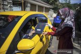 Seorang guru memberikan rapor kepada orang tua siswa saat penerimaan rapor dengan layanan tanpa turun di SMP IT Insan Sejahtera, Kampung Toga, Kabupaten Sumedang, Jawa Barat, Selasa (22/6/2021). Sebanyak 55 siswa kelas 9 tingkat SMP Insan Sejahtera mengikuti pembagian rapor dengan layanan tanpa turun guna mencegah kerumunan di tengah pandemi COVID-19. ANTARA FOTO/Raisan Al Farisi/agr