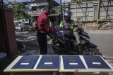 Seorang guru memberikan rapor kepada pengemudi ojek daring saat penerimaan rapor dengan layanan tanpa turun di SMP IT Insan Sejahtera, Kampung Toga, Kabupaten Sumedang, Jawa Barat, Selasa (22/6/2021). Sebanyak 55 siswa kelas 9 tingkat SMP Insan Sejahtera mengikuti pembagian rapor dengan layanan tanpa turun guna mencegah kerumunan di tengah pandemi COVID-19. ANTARA FOTO/Raisan Al Farisi/agr