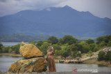 Pengunjung berfoto dengan latar belakang Pegunungan Meratus di Kawasan Wisata Bukit Batu, Desa Sungai Luar Tiwingan Baru, Kabupaten Banjar, Kalimantan Selatan, Rabu (23/6/2021). Wisata Bukit Batu yang terletak di kawasan waduk Riam Kanan itu  menjadi salah satu destinasi wisata alam yang menawarkan pemandangan Pegunungan Meratus dan waduk Riam Kanan serta memiliki fasilitas umum musala yang ramai di kunjungi wisatawan lokal. Foto Antaranews Kalsel/Bayu Pratama S.