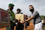 Ketua Yayasan Buddha Tzu Chi Jawa Timur Valentino (kanan) menyerahkan secara simbolis bantuan sosial kepada prajurit TNI sebelum didistribusian saat penyerahan bantuan sosial dari TNI, Polri dan pemerintah daerah bersama Yayasan Buddha Tzu Chi serta pengusaha peduli NKRI di Stadion Wilis Kota Madiun, Jawa Timur, Kamis (24/6/2021). Bantuan berupa 35 ton beras dan 70 ribu masker akan didistribusikan dari rumah ke rumah warga terdampak pandemi COVID-19 di Kota dan Kabupaten Madiun untuk meringankan beban kebutuhan serta masker guna pencegahan penularan COVID-19. Antara Jatim/Siswowidodo/zk