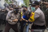 Polisi mengamankan seorang mahasiswa saat aksi unjuk rasa di kawasan Jalan Lambung Mangkurat, Banjarmasin, Kalimantan Selatan, Kamis (24/6/2021). Aksi menyerukan menolak adanya pelemahan terhadap lembaga antirasuah, Komisi Pemberantasan Korupsi (KPK) tersebut sempat terjadi kericuhan akibat Ketua DPRD Kalsel Supian HK yang tak kunjung datang menemui para demonstran, sesuai tuntutan mereka. Foto Antaranews Kalsel/Bayu Pratama S.