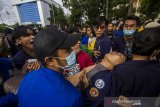 Sejumlah mahasiswa membawa temannya yang pingsan saat aksi unjuk rasa di kawasan Jalan Lambung Mangkurat, Banjarmasin, Kalimantan Selatan, Kamis (24/6/2021). Aksi menyerukan menolak adanya pelemahan terhadap lembaga antirasuah, Komisi Pemberantasan Korupsi (KPK) tersebut sempat terjadi kericuhan akibat Ketua DPRD Kalsel Supian HK yang tak kunjung datang menemui para demonstran, sesuai tuntutan mereka. Foto Antaranews Kalsel/Bayu Pratama S.