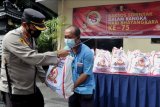 Polisi menyerahkan bantuan paket sembako kepada warga saat kegiatan bakti sosial di Denpasar, Bali, Jumat (25/6/2021). Bakti sosial serentak tersebut diselenggarakan dalam rangka Hari Bhayangkara ke-75 untuk membantu masyarakat khususnya warga yang perekonomiannya terdampak pandemi COVID-19. ANTARA FOTO/Fikri Yusuf/nym.