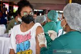 Seorang warga mendapat suntikan vaksin saat vaksinasi COVID-19 massal di Lapangan Merdeka, Kota Ambon, Provinsi Maluku, Sabtu (26/6/2021). Pemerintah daerah bersama TNI dan Polri bersinergi menggelar program 