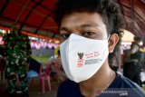 Seorang anak muda mengenakan masker saat mengantre di vaksinasi COVID-19 massal di Lapangan Merdeka, Kota Ambon, Provinsi Maluku, Sabtu (26/6/2021). (ANTARA FOTO/FB Anggoro)