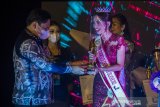 Sekretaris Daerah Provinsi Kalimantan Selatan Roy Rizali Anwar (kiri) menyerahkan trophy kepada pemenang Puteri Pariwisata Kalsel 2021 Winda Juniar (kanan) dalam acara grand final pemilihan Puteri Pariwisata Kalimantan Selatan di Swiss Bell Hotel, Banjarmasin, Kalimantan Selatan, Sabtu (26/6/2021). Pemilihan Puteri Pariwisata Kalimantan Selatan tersebut dimenangkan oleh Winda Juniar asal Banjarmasin setelah bersaing dengan 16 finalis Puteri Pariwisata Kalsel saat Grand Final dan akan berperan dalam mempromosikan pariwisata Kalimantan Selatan serta memotivasi masyarakat untuk mengembangkan potensi wisata yang ada di Kalsel. Foto Antaranews Kalsel/Bayu Pratama S.