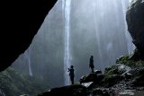 Wisatawan menikmati panorama air terjun tumpak sewu di Pronojiwo, Lumajang, Jawa Timur, Minggu (27/6/2021). Air terjun berbentuk setengah lingkaran di kaki Gunung Semeru itu menjadi salah satu wisata alam unggulan di Lumajang. Antara Jatim/Budi Candra Setya/zk