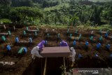 Petugas memakamkan jenazah di pemakaman khusus COVID-19 di Cipageran, Cimahi, Jawa Barat, Rabu (30/6/2021). Menurut Dinas Perumahan dan Kawasan Pemukiman (DPKP) Kota Cimahi ketersediaan lahan pemakaman COVID-19 terus berkurang akibat terus meningkatnya angka kematian akibat COVID-19 sementara Kota Cimahi masih terdata sebagai salah satu zona merah dari 11 daerah zona merah COVID-19 di Jawa Barat. ANTARA FOTO/Novrian Arbi/agr