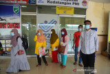 KEPULANGAN PMI ASAL ACEH DARI MALAYSIA. Petugas Badan Perlindungan Pekerjaan Migran Indonesia (kiri) bersama Dinsos Aceh menyambut kedatangan sejumlah Pekerja Migran Indonesia (PMI) saat tiba di Bandara Internasional Sultan Iskandar Muda , Aceh Besar, Aceh, Jumat (2/6/2021). Sembilan Pekerja Migran Indonesia (PMI) asal Aceh yang dideportasi dari Malasyaia itu dipulangkan dalam dua tahap transit di Jakarta karena tidak ada penerbangan langsung ke Aceh dan mereka langsung  menjalani karantina selama lima hari dan pemeriksaan kesehatan guna mencegah penyebaran COVID-19. ANTARA FOTO/Ampelsa.