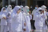 Sejumlah tenaga kesehatan memberikan hormat kepada mendiang Ilah Kurnia di RSUD Indramayu, Jawa Barat, Jumat (2/7/2021). Penghormatan tersebut diberikan kepada bidan Ilah Kurnia yang meninggal dunia akibat COVID-19. ANTARA FOTO/Dedhez Anggara/agr