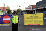 Polisi berjaga saat penutupan ruas jalan Jenderal Ahmad Yani, Indramayu, Jawa Barat, Senin (5/7/2021). Penutupan sejumlah ruas jalan protokol tersebut sebagai upaya penegakan aturan Pemberlakukan Pembatasan Kegiatan Masyarakat (PPKM) Darurat untuk mengurangi mobilitas guna mencegah penyebaran COVID-19. ANTARAFOTO/Dedhez Anggara/agr