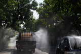 Petugas menyemprotkan cairan disinfektan di kawasan zona merah COVID-19 di Kota Madiun, Jawa Timur, Kamis (1/7/2021). Pemkot Madiun mengerahkan puluhan petugas untuk melakukan penyemprotan cairan disinfektan secara massal di sejumlah kawasan di daerah yang saat ini berstatus zona merah tersebut guna pengendalian penyebaran COVID-19. Antara Jatim/Siswowidodo/zk