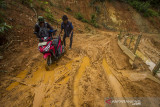 Warga mendorong motornya akibat kesulitan melintasi jalan yang rusak tertutup lumpur tanah longsor di Desa Hinas Kanan, Kabupaten Hulu Sungai Tengah, Kalimantan Selatan, Senin (5/7/2021). Warga setempat mengeluhkan jalan penghubung antar desa yang berada di Kecamatan Hantakan tersebut masih rusak parah akibat longsor pascabanjir bandang dan hingga kini belum diperbaiki sehingga mengganggu aktivitas warga. Foto Antaranews Kalsel/Bayu Pratama S.