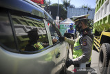 Petugas kepolisian memeriksa kelengkapan surat seorang pengendara saat operasi yustisi PPKM Darurat di Jatinangor, Kabupaten Sumedang, Jawa Barat, Selasa (6/7/2021). Operasi yang dilakukan oleh petugas gabungan Polri, TNI, Dinas Perhubungan dan Satpol PP tersebut dilakukan dalam rangka tindak lanjut PPKM Darurat Jawa dan Bali guna menghentikan lonjakan kasus COVID-19. ANTARA FOTO/Raisan Al Farisi/agr