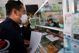 Kasat Reskrim Polres Blitar AKP Ardyan Yudo Setyantono (Kiri) memeriksa penjualan jenis obat tertentu saat sidak di salah satu apotek di Blitar, Jawa Timur, Rabu (7/7/2021). Sidak tersebut bertujuan untuk mengantisipasi penjualan obat diatas Harga Eceran Tertinggi (HET) dan memastikan ketersediaan serta penyaluran oksigen di sejumlah distributor pengisian oksigen. Antara Jatim/Irfan Anshori/zk