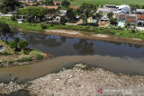 Foto udara perbedaan warna antara Sungai Citarik (bawah) dan Sungai Citarum (atas) yang tercemar limbah di Sapan, Kabupaten Bandung, Jawa Barat, Rabu (7/7/2021). Data dari Direktorat Jenderal Pengendalian Pencemaran dan Kerusakan Lingkungan Kementerian Lingkungan Hidup dan Kehutanan mencatat sebanyak 70,13 persen pencemaran air Sungai Citarum diakibatkan oleh limbah domestik. ANTARA FOTO/Raisan Al Farisi/agr