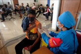 Vaksinator menyuntikkan vaksin kepada seorang penumpang bus dalam Gerai Vaksin Presisi Bhakti Kesehatan Bhayangkara Untuk Negeri di Terminal Tipe A Mengwi, Badung, Bali, Jumat (9/7/2021). Kegiatan vaksinasi COVID-19 yang digelar selama pelaksanaan Pemberlakuan Pembatasan Kegiatan Masyarakat (PPKM) Darurat tersebut menyasar Pelaku Perjalanan Dalam Negeri (PPDN) dengan jumlah kuota 150 orang per hari itu bertujuan mendukung percepatan penanganan COVID-19 untuk masyarakat sehat dan pemulihan ekonomi nasional menuju Indonesia maju. ANTARA FOTO/Nyoman Hendra Wibowo/nym.