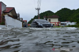 PERINGATAN POTENSI CURAH HUJAN TINGGI BERDAMPAK BANJIR. Kendaraan melintasi jalan terendam banjir di komplek perumahan Villa Buana, Desa Ajun, Kecamatan Darul Imarah, Kabupaten Aceh Besar, Aceh, Sabtu (10/7/2021). Badan Meteorologi, Klimatologi dan Geofisika (BMKG) di daerah itu mengeluarkan peringatan dini waspada potensi curah hujan lebat disertai petir dan angin kencang di sejumlah daerah wilayah Aceh yang berlangsung hingga tanggal 12 Juli 20021 berdampak banjir dan longsor. ANTARA FOTO/Ampelsa.