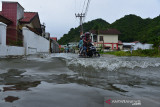 PERINGATAN POTENSI CURAH HUJAN TINGGI BERDAMPAK BANJIR. Warga mengendari sepeda motor melintasi jalan terendam banjir di komplek perumahan Villa Buana, Desa Ajun, Kecamatan Darul Imarah, Kabupaten Aceh Besar, Aceh, Sabtu (10/7/2021). Badan Meteorologi, Klimatologi dan Geofisika (BMKG) di daerah itu mengeluarkan peringatan dini waspada potensi curah hujan lebat disertai petir dan angin kencang di sejumlah daerah wilayah Aceh yang berlangsung hingga tanggal 12 Juli 20021 berdampak banjir dan longsor. ANTARA FOTO/Ampelsa.