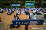 Sejumlah siswa bersiap mengikuti pembelajaran tatap muka (PTM) di SMP Negeri 7 Banjarmasin, Kalimantan Selatan, Senin (12/7/2021). Pemerintah Kota Banjarmasin melalui Dinas Pendidikan Kota Banjarmasin memutuskan melaksanakan PTM dengan penerapan disiplin protokol kesehatan yang ketat di tengah kenaikan kasus COVID-19. Foto Antaranews Kalsel/Bayu Pratama S.