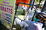 Warga mengambil makanan yang disediakan gratis di kawasan Kesiman, Denpasar, Bali, Rabu (14/7/2021). Aksi berbagi makanan dan sembako dengan cara digantungkan di rak pangan tersebut sebagai bentuk solidaritas dan saling membantu antar warga yang terdampak pandemi COVID-19 pada masa PPKM Darurat. ANTARA FOTO/Fikri Yusuf/nym.