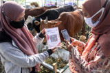 Penjual melayani pembeli melakukan pembayaran digital via QRIS saat pembelian hewan di kawasan pasar kurban Merr Surabaya, Jawa Timur, Kamis (15/7/2021). Penjual hewan qurban menawarkan secara digital dengan aplikasi ternaknesia untuk pembelian hewan kurban dan belanja ke kandang dengan teknologi Virtual Reality (VR) selama masa Pemberlakuan Pembatasan Kegiatan Masyarakat (PPKM) Darurat. Antara Jatim/Umarul Faruq/zk