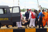 Sejumlah petugas membawa satu kantung jenazah awak kapal yang berhasil ditemukan SAR ke dalam ambulans di dermaga Kesatuan Penjagaan Laut dan Pantai (KPLP) di Pontianak, Kalimantan Barat, Kamis (15/7/2021). Hingga saat ini Tim SAR gabungan masih melakukan pencarian terhadap 51 awak dari 12 kapal motor ikan dan 2 kapal tunda (tugboat) yang tenggelam di tiga lokasi berbeda yaitu di Perairan Muara Jungkat, Muara Kubu serta Muara Pemangkat akibat cuaca buruk pada Selasa (13/7/2021) malam dan Rabu pagi (14/7/2021). ANTARA FOTO/Jessica Helena Wuysang/nym.