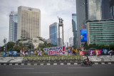 Pengendara sepeda motor melintas di dekat poster maskot dan slogan Pekan Olahraga Nasional (PON) XX Papua di Bundaran Hotel Indonesia, Jakarta, Rabu (14/7/2021). Presiden Joko Widodo memastikan PON XX Papua tetap akan berlangsung pada 2-15 Oktober 2021. ANTARA FOTO/Aditya Pradana Putra/nym.