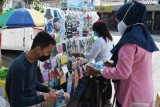  Pedagang kaki lima masker melayani pembeli di Kota Madiun, Jawa Timur, Sabtu (17/7/2021). Pedagang yang sebelumnya berjualan celana di pasar tersebut memanfaatkan momentum meningkatnya permintaan masker untuk pencegahan penularan COVID-19 dengan beralih menjadi pedagang dadakan yang menjual berbagai jenis masker dengan harga antara Rp15.000 per kemasan isi 50 lembar hingga Rp10.000 per lembar dengan omzet antara Rp300 ribu hingga Rp500 ribu per hari. Antara Jatim/Siswowidodo/zk