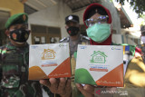 Petugas kesehatan menunjukan paket obat COVID-19 gratis yang akan dibagikan kepada pasien COVID-19 di Indramayu, Jawa Barat, Senin (19/7/2021). Pemerintah pusat resmi membagikan sebanyak 300.000 paket obat gratis berupa multivitamin, Azithtromycin, dan Oseltamivir bagi pasien COVID-19 yang menjalani isolasi mandiri. ANTARA FOTO/Dedhez Anggara/agr