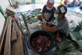  Takmir masjid Baitul Fatah memotong daging kurban kemudian meletakannya diatas daun pisang dan daun pohon jati yang dijadikan pembungkus di Kota Blitar, Jawa Timur, Selasa (20/7/2021). Warga didaerah itu memanfaatkan dedaunan untuk membungkus daging kurban dengan tujuan untuk mendukung program pemerintah dalam meminimalisir penggunaan plastik (diet plastik). Antara Jatim/Irfan Anshori/zk