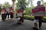 Sejumlah warga menerima bantuan Program Keluarga Harapan (PKH) dan beras secara simbolis di halaman Kantor Wali Kota Denpasar, Bali, Rabu (21/7/2021). Pemerintah Kota Denpasar memberikan sebanyak tiga jenis bantuan yakni Bantuan Pangan Non Tunai (BPNT), Program Keluarga Harapan (PKH), dan Bantuan Sosial Tunai (BST) kepada 14.477 keluarga penerima manfaat (KPM) untuk membantu perekonomian masyarakat pada masa pandemi COVID-19. ANTARA FOTO/Nyoman Hendra Wibowo/nym.