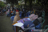 Petugas melakukan pendaftaran saat pembagian bantuan sosial tunai di Jajaway, Antapani Kidul, Bandung, Jawa Barat, Kamis (22/7/2021). Gubernur Jawa Barat, Ridwan Kamil mengatakan, bantuan sosial dari pemerintah pusat bagi warga terdampak PPKM di Jawa Barat mengalami peningkatan dari sekitar 40 persen menjadi 64 persen dari total penduduk Jawa Barat. ANTARA FOTO/Raisan Al Farisi/agr