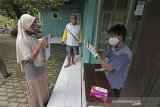 Juru Bayar Kantor Pos Indonesia mendokumentasikan warga penerima Bantuan Sosial Tunai (BST) Kemensos di desa Tegalurung, Balongan, Indramayu, Jawa Barat, Jumat (23/7/2021). Kementerian Sosial melalui PT Pos Indonesia (Persero) menyalurkan Bantuan Sosial Tunai (BST) untuk periode Mei-Juni 2021 sebesar Rp600 ribu secara jemput bola atau di kirim ke rumah Keluarga Penerima Manfaat (KPM). ANTARA FOTO/Dedhez Anggara/agr