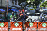 Sandi Hendrayana, mengangkat sepedanya melintasi pembatas jalan untuk mengantarkan pesanan di Cihideung, Kota Tasikmalaya, Jawa Barat, Minggu (25/7/2021). Sandi merupakan pendiri Orangbike Messenger Service (OMS), jasa kurir bersepeda di Tasikmalaya sebagai kampanye ramah lingkungan guna mengurangi polusi udara. ANTARA FOTO/Adeng Bustomi/agr