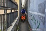 Sandi Hendrayana, menggowes sepeda kargo memasuki jalan gang untuk mengantarkan pesanan di kawasan Cihideung, Kota Tasikmalaya, Jawa Barat, Minggu (25/7/2021). Sandi merupakan pendiri Orangbike Messenger Service (OMS), jasa kurir bersepeda di Tasikmalaya sebagai kampanye ramah lingkungan guna mengurangi polusi udara. ANTARA FOTO/Adeng Bustomi/agr