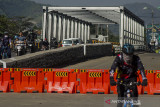 Sejumlah pengendara melintas pada sisi jalur Jembatan Sungai Citarum yang ditutup di Jalan Raya Dayeuhkolot, Kabupaten Bandung, Jawa Barat, Minggu (25/7/2021). Jembatan yang menjadi salah satu akses penguhubung jalan Kota Bandung dan Kabupaten Bandung tersebut mengalami keretakkan pada bagian bawah sehingga terpaksa ditutup dan arus lalu lintas dialihkan sementara untuk selanjutnya dilakukan penanganan perbaikan oleh Dinas Bina Marga dan Tata Ruang (DBMTR) Provinsi Jawa Barat dan Dinas Pekerjaan Umum dan Penataan Ruang Kabupaten Bandung . ANTARA FOTO/Novrian Arbi/agr