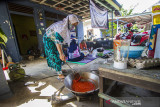 Warga memasak lauk di posko dapur umum swadaya masyarakat di Kelurahan Mentaos, Banjarbaru, Kalimantan Selatan, Rabu (28/7/2021). Dapur umum yang didirikan oleh Alumni SMP Negeri 2 Banjarbaru bersama warga setempat saat Pemberlakuan Pembatasan Kegiatan Masyarakat (PPKM) level 4 tersebut untuk membantu warga yang melakukan isolasi mandiri akibat terpapar COVID-19 serta mendukung program pemerintah daerah yaitu Gerakan peduli isolasi mandiri (Garda Lima) di kelurahan dan kecamatan se-Kota Banjarbaru. Foto Antaranews Kalsel/Bayu Pratama S.