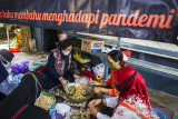 Sejumlah warga menyiapkan hidangan makanan di posko dapur umum swadaya masyarakat di Kelurahan Mentaos, Banjarbaru, Kalimantan Selatan, Rabu (28/7/2021). Dapur umum yang didirikan oleh Alumni SMP Negeri 2 Banjarbaru bersama warga setempat saat Pemberlakuan Pembatasan Kegiatan Masyarakat (PPKM) level 4 tersebut untuk membantu warga yang melakukan isolasi mandiri akibat terpapar COVID-19 serta mendukung program pemerintah daerah yaitu Gerakan peduli isolasi mandiri (Garda Lima) di kelurahan dan kecamatan se-Kota Banjarbaru. Foto Antaranews Kalsel/Bayu Pratama S.