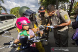 Petugas Satpol PP menegur warga tidak menggunakan masker saat pelaksanaan operasi yustisi Pemberlakuan Pembatasan Kegiatan Masyarakat (PPKM) level 4 di Jalan Ahmad Yani Km 6, Banjarmasin, Kalimantan Selatan, Rabu (28/7/2021). Hari pertama penegakan PPKM level 4 di Banjarmasin puluhan pengendara terjaring petugas gabungan karena melanggar protokol kesehatan yakni tidak menggunakan masker dan hanya diberikan teguran secara lisan tertulis. Foto Antaranews Kalsel/Bayu Pratama S.