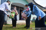 KEMENKUMHAM ANTAR LANGSUNG SEMBAKO KE RUMAH WARGA. Kepala Kanwil Kementerian Hukum dan HAM provinsi Aceh, Meurah Budiman (edua kanan) dengan menerapkan protokol kesehatan menyerahkan paket sembako kepada warga terdampak COVID-19 di Desa Kajhu, Kecamatan Baitussalam, Kabupaten Aceh Besar, Aceh, Selasa (3/8/2021). Kemenkumham memberikan bantuan sosial sebanyak 46.614 paket dan dana sosial sebesar 700 juta rupiah kepada masyarakat di seluruh Indonesia terdampak langsung pandemi Covid-19 dan sebanyak 616 kepala keluarga di antaranya disalurkan di provinsi Aceh. ANTARA FOTO/Ampelsa.