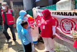 Relawan PMI Cisarua, Bogor, Jawa Barat, mengukur suhu warga dalam melanjutkan kegiatan edukasi kesehatan kepada masyarakat mengenai pentingnya mengikuti protokol 6M. (Foto Antara/HO/PMI/IFRC).