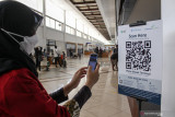 Calon penumpang pesawat melakukan scan QR code melalui aplikasi PeduliLindungi di Bandara Internasional Juanda Surabaya di Sidoarjo, Jawa Timur, Jumat (6/8/2021). PT Angkasa Pura I Kantor Cabang Bandara Juanda mewajibkan calon penumpang pesawat yang akan terbang memiliki aplikasi PeduliLindungi, hal tersebut untuk mendukung penerapan Surat Edaran Menteri Kesehatan tentang Digitalisasi dokumen kesehatan bagi pengguna transportasi udara yang terintegrasi dengan aplikasi tersebut. Antara Jatim/Umarul Faruq/zk