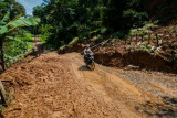 Warga menggunakan roda dua melintas di jalan yang longsor di Desa Banjarsari, Lebak, Banten, Jumat (6/8/2021). Hujan deras yang mengguyur daerah tersebut mengakibatkan jalan antardesa tertimbun longsor pada Rabu (5/8/2021) malam, dikhawatirkan terjadi longsor kembali jika hujan karena tanah yang masih labil. (ANTARA FOTO/Muhammad Bagus Khoirunas/foc).